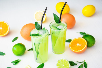 Transparent refreshing drink with cucumber, limes and orange