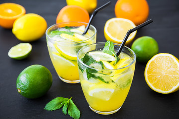 Refreshing lemonade drink with limes, lemons in glasses