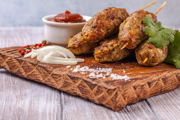 Lulya-kebab. Shish kebab on a stick, minced meat. Traditional Caucasian dish. With green salad, ketchup, spices.