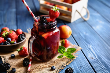 Traditional Sangria drink with red wine, tropical fruit and berries - obrazy, fototapety, plakaty