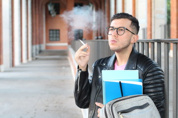 Ethnic student smoking on campus close up