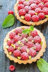 Tartlets with chocolate,fresh raspberries and pistachios.