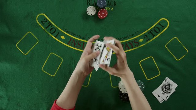Top view of hands shuffling the cards for a blackjack game