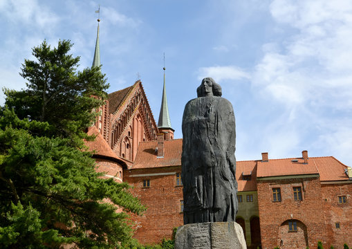 FROMBORK, POLAND. A monument to the scientist Nicolaus Copernicus against the background of a cathedral complex