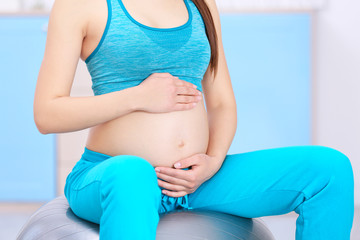Fototapeta na wymiar Young pregnant woman training in gym. Health concept