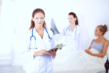 Fototapeta premium Woman doctor with folder standing at hospital