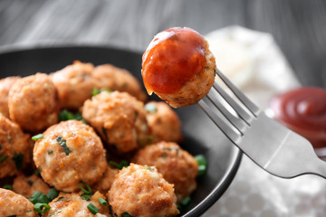 Fork and plate with delicious turkey meatballs on table, closeup