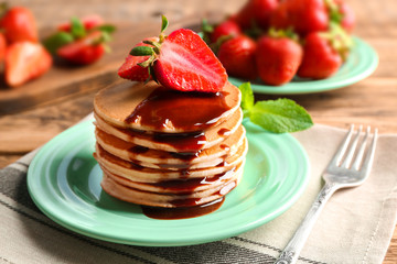 Plate with delicious pancakes on table