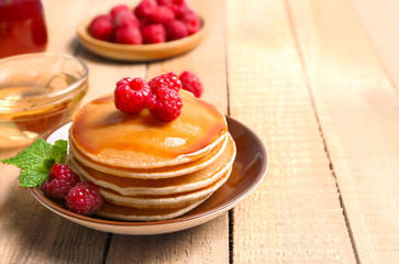 Plate with delicious pancakes on table