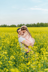 Fototapeta premium Man with child in a yellow field at sunset