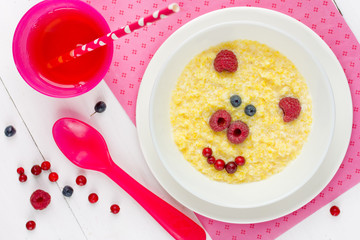 Baby healthy breakfast - sweet corn porridge with berry in shape cute pig