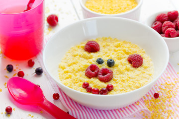 Baby healthy breakfast - sweet corn porridge with berry in shape cute pig