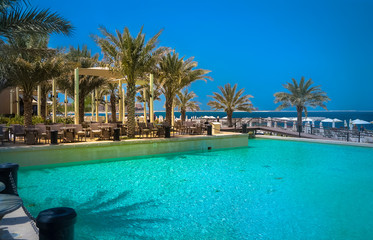 Dubai. Heavenly oasis in Ras al Khaimah. The beach with sunbeds and sunshades in Dubai, on the shores of the Arabian Gulf. Toning.
