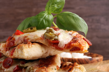 Hot pizza slice with melting cheese on a rustic wooden table. Italien food concept
