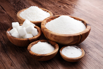 Sugar composition with white sugar in bowls on wooden board