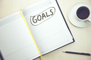 notebook with goals and a cup of coffee