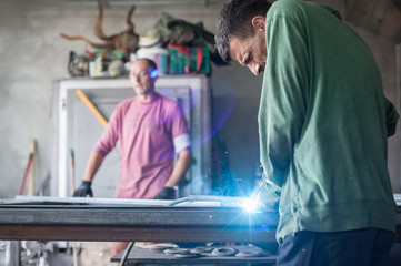 Obraz premium Industrial worker welding the steel structure in the workshop
