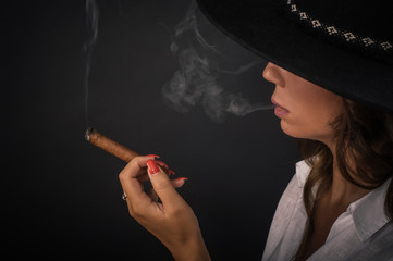 Portrait of sexy elegant lady woman with hat smoking cigar