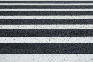 Fototapeta premium Perspective view of white markings crosswalk lines on a asphalt road (background)