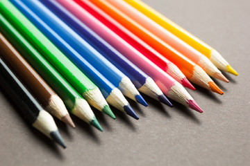 Set of colored pencils on a gray background.