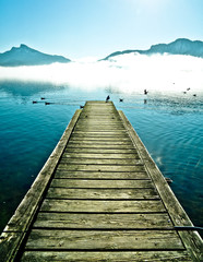 Obraz premium View on Pier with seagulls by mountain lake Mondsee in Autria