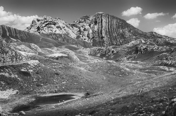 Small lake on the mountain plateau. Black and white.