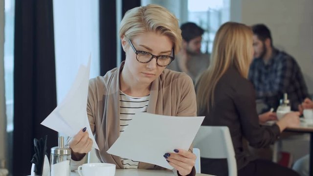 Businesswoman working with documents in coffee shop