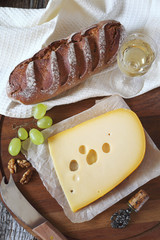 Maasdam cheese, bread, grapes and glass of white wine