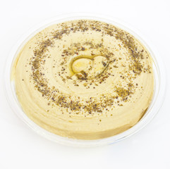 Mediterranean style hummus in plastic container.
