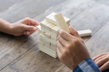 Game of physical and mental skill. Keep balance. girl builds tower of wood blocks. Entertainment activity. Education, development. The girls collect a sprawling constriction of wooden Blocks