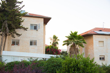 The construction of a new district in Jerusalem. The appearance of the city in the desert. Typical houses on background of mountains in Jerusalem, Israel. Solar panels on the roofs of houses