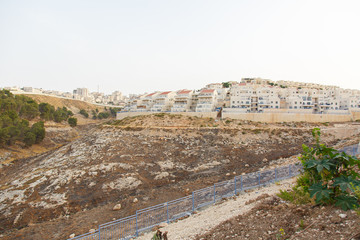 The construction of a new district in Jerusalem. The appearance of the city in the desert. Typical houses on background of mountains in Jerusalem, Israel. Solar panels on the roofs of houses