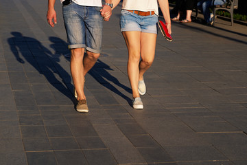 Fototapeta na wymiar Cropped image of romantic young beautiful couple walking on city holding hands
