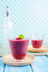 Berry Smoothie with Mint, black currant, red currant, raspberry and blueberry on blue wooden table
