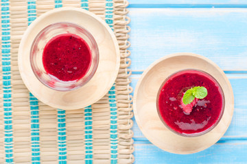 Berry Smoothie with Mint, black currant, red currant, raspberry and blueberry on blue wooden table