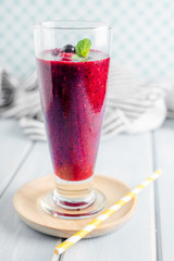 Berry Smoothie with Mint, black currant, red currant, raspberry and blueberry on blue wooden table