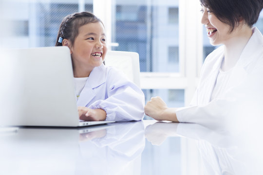 Mother and daughter are studying with a laptop computer - Powered by Adobe
