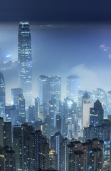 Fototapeta na wymiar Misty night view of Victoria harbor in Hong Kong city