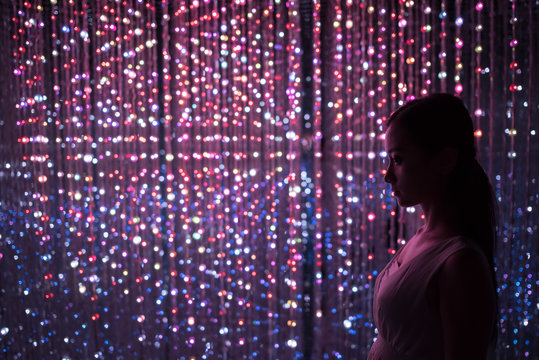 a girl before many lights in the night