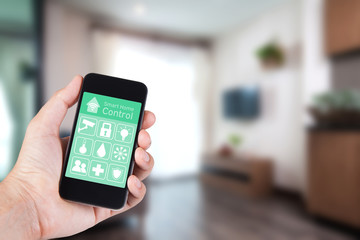 Hand using smartphone to smart home app on mobile for remote control everything in home by wifi network.