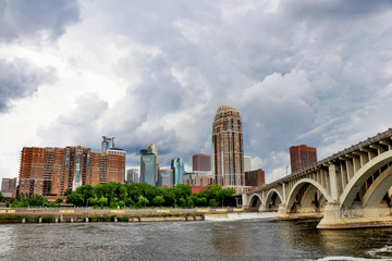 Cloudy morning in Minneapolis. Minneapolis downtown skyline and Third Avenue Bridge above Saint Anthony Falls, Mississippi river. Midwest USA, Minnesota state.