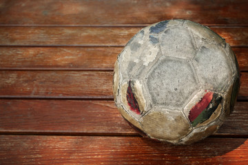 Old soccer ball on wooden floor top view and copy space