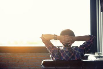 Relaxed woman lying on comfortable sofa n the coffee shop with a warm light