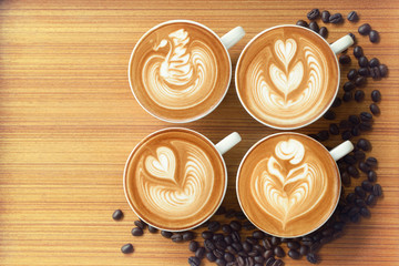 Four cup of coffee latte art and coffee beans.