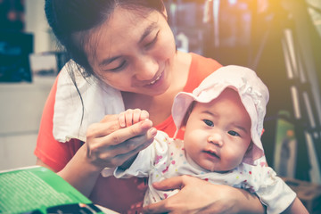 Asian mother smiling and take care her daughter with love. Vintage tone.