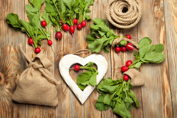 Fresh radishes and a bag on a wooden background