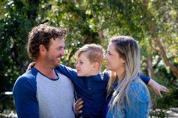 Father, Mother and young son together outdoors in sunlight in park © CreativeFire