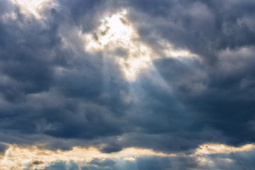 Obraz premium rays of the sun make their way through dramatic clouds