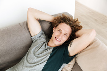 Handsome smiling man lies on sofa