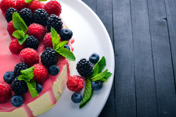 Cake with butter and fresh berries and fruits. Dessert. On a wooden background. Top view. Free space for your text.
